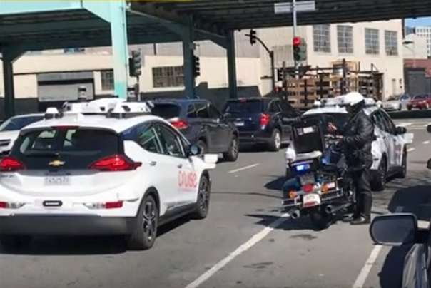 policajac piše kaznu samovozećem automobilu