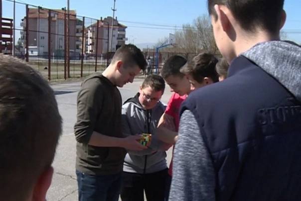 Petar Mladenović pokazuje dečacima rubikovu kocku FOTO: RTK2