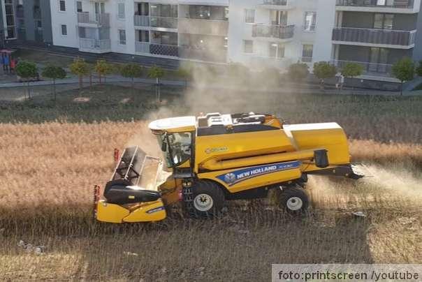 kombajn berba useva između stambenih zgrada