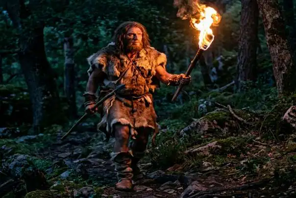 praistorijski čovek nosi vatru